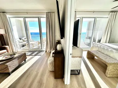 a bedroom with a bed and a view of the ocean at Ocean Reef 1002 in Panama City Beach