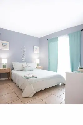 a bedroom with a white bed and blue walls at WALK TO BEACH Perfect Family Getaway Sleep 6 in Panama City Beach