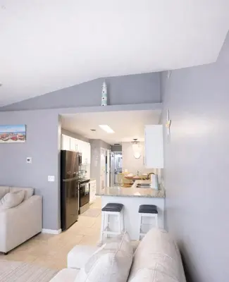 a living room with a couch and a kitchen at WALK TO BEACH Perfect Family Getaway Sleep 6 in Panama City Beach