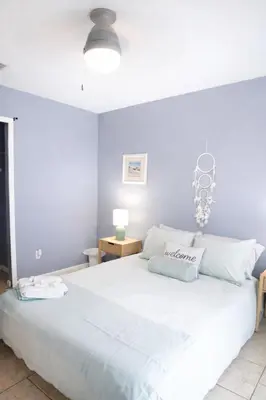 a bedroom with a large bed with white sheets at WALK TO BEACH Perfect Family Getaway Sleep 6 in Panama City Beach