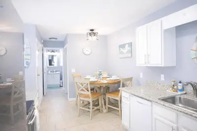 a kitchen with a table and a dining room at WALK TO BEACH Perfect Family Getaway Sleep 6 in Panama City Beach