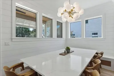 a white dining room with a white table and chairs at The Gathering Place by Travel Life Vacations in Santa Rosa Beach