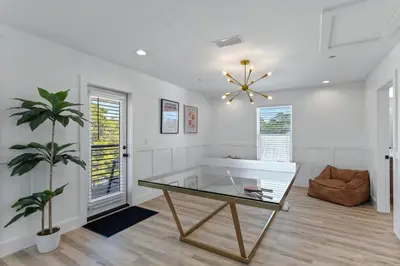 a living room with a table and a plant at The Gathering Place by Travel Life Vacations in Santa Rosa Beach