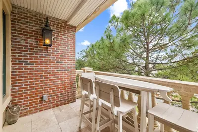 a patio with a table and chairs on a brick wall at The Magnolia by 30A Escapes in Rosemary Beach