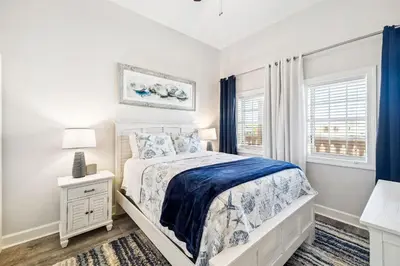 a white bedroom with a bed and a window at The Magnolia by 30A Escapes in Rosemary Beach