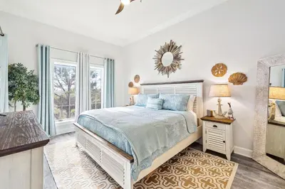a white bedroom with a bed and a window at The Magnolia by 30A Escapes in Rosemary Beach
