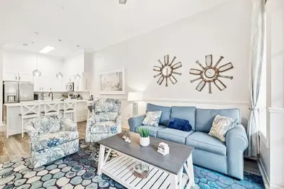 a living room with a blue couch and two chairs at The Magnolia by 30A Escapes in Rosemary Beach