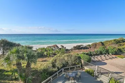 a staircase leading to a beach with chairs and the ocean at Be Still 30A in Santa Rosa Beach