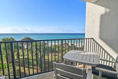 a balcony with a table and chairs and the ocean at Be Still 30A in Santa Rosa Beach