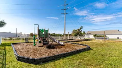 a playground with a slide in a yard at Charming house near the beach in Panama City Beach