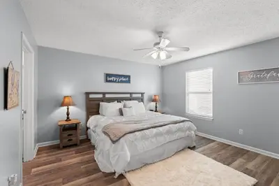 a bedroom with a bed and a ceiling fan at Charming house near the beach in Panama City Beach