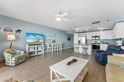 a living room and kitchen with a couch and a table at Beach-Ready Resort Condo! Pools & Walk to Beach by Dolce Vita Getaways in Panama City Beach