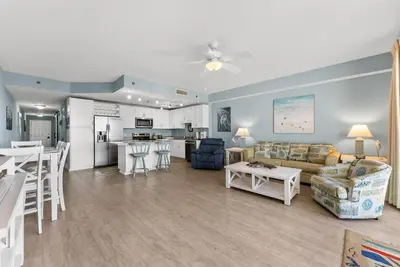 a living room and kitchen with a couch and a table at Beach-Ready Resort Condo! Pools & Walk to Beach by Dolce Vita Getaways in Panama City Beach