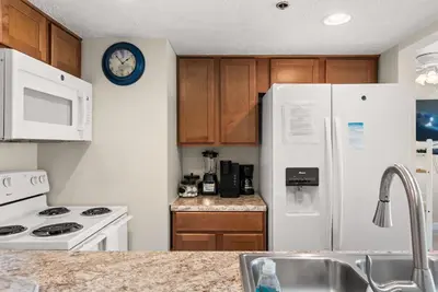 a kitchen with white appliances and a white refrigerator at Amazing Gulf Views! Resort! Beach Chair Service by Dolce Vita Getaways PCB in Panama City Beach
