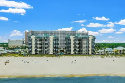 a hotel on the beach with people on the beach at Amazing Gulf Views! Resort! Beach Chair Service by Dolce Vita Getaways PCB in Panama City Beach