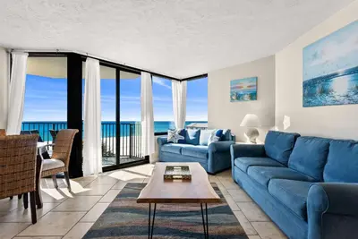 a living room with a blue couch and a table at Amazing Gulf Views! Resort! Beach Chair Service by Dolce Vita Getaways PCB in Panama City Beach