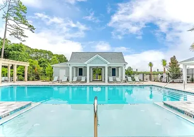 a house with a swimming pool in front of a house at Coastal Retreat, 1 Mile to Beach, Pool & Golf Cart in Panama City Beach