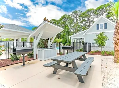 a picnic table and a grill on a patio at Coastal Retreat, 1 Mile to Beach, Pool & Golf Cart in Panama City Beach