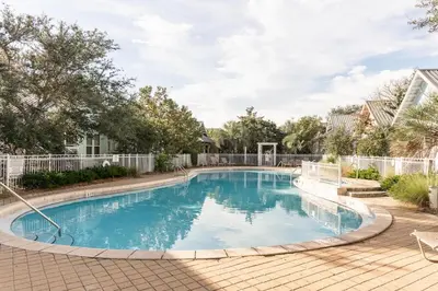 a large swimming pool in a yard with trees at Glory Days 30A - Pool, Bikes & Close Beach Access in Inlet Beach