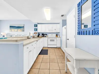 a kitchen with white cabinets and a counter top at Majestic Beach Towers 1-1906 in Panama City Beach