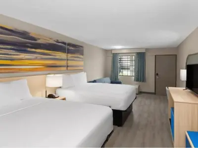 a hotel room with two beds and a flat screen tv at The Barefoot Hotel in Panama City Beach
