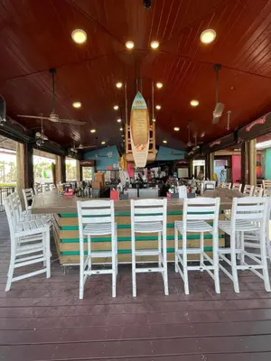 a group of white chairs and tables in a restaurant at The Barefoot Hotel in Panama City Beach