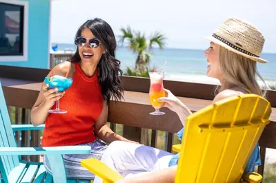two women sitting at a table with drinks at The Barefoot Hotel in Panama City Beach