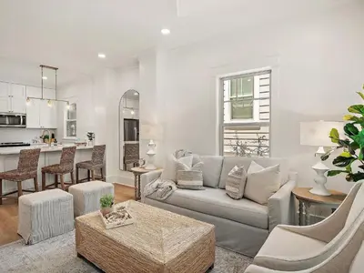 a living room with a couch and a kitchen at Elegant 5BR 30A Home w Hot tub & Pool in Santa Rosa Beach