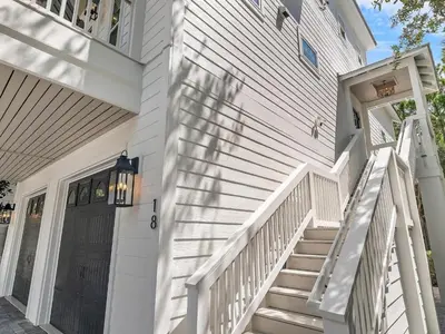 a white house with a staircase leading to a door at Elegant 5BR 30A Home w Hot tub & Pool in Santa Rosa Beach