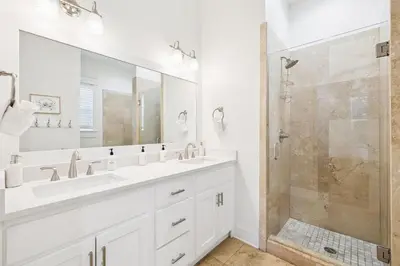 a white bathroom with two sinks and a shower at Sea La Vie on 30A in Rosemary Beach