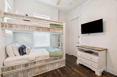 a bedroom with a bunk bed and a flat screen tv at Sea La Vie on 30A in Rosemary Beach