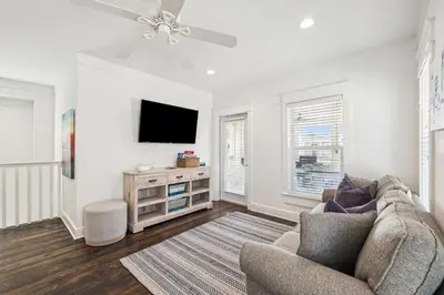 a living room with a couch and a flat screen tv at Sea La Vie on 30A in Rosemary Beach