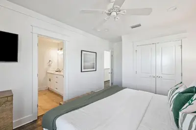 a white bedroom with a bed and a ceiling fan at Sea La Vie on 30A in Rosemary Beach