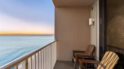 a balcony with two chairs and a view of the ocean at Beachfront Tidewater Resort Condo w Pools Hot Tubs Pier Park Nearby Tidewater Beach by AvantStay in Panama City Beach