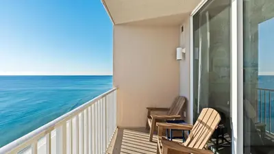 a balcony with two chairs and the ocean at Beachfront Tidewater Resort Condo w Pools Hot Tubs Pier Park Nearby Tidewater Beach by AvantStay in Panama City Beach