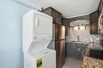 a kitchen with a white refrigerator and a sink at The Summit 922 - Relaxation meets the Shoreline in Panama City Beach