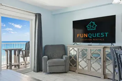 a living room with a tv and a chair at The Summit 922 - Relaxation meets the Shoreline in Panama City Beach