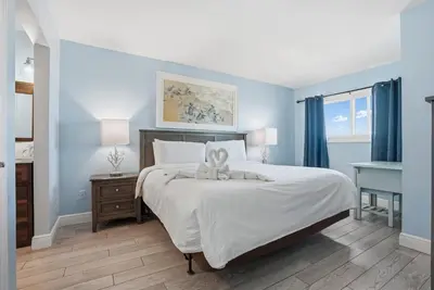a bedroom with a large white bed with a bow on it at The Summit 922 - Relaxation meets the Shoreline in Panama City Beach
