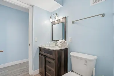a bathroom with a toilet and a sink and a mirror at The Summit 922 - Relaxation meets the Shoreline in Panama City Beach