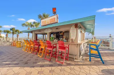a row of colorful chairs in front of a restaurant at The Summit 922 - Relaxation meets the Shoreline in Panama City Beach