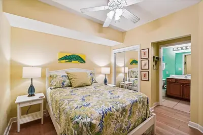 a bedroom with a bed and a bathroom at Seychelles 602 by Emerald Coast Retreats in Panama City Beach