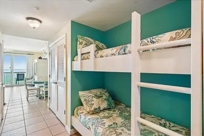 a bedroom with bunk beds and a living room at Seychelles 602 by Emerald Coast Retreats in Panama City Beach