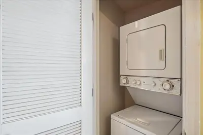 a bathroom with a washer and dryer next to a window at Seychelles 602 by Emerald Coast Retreats in Panama City Beach