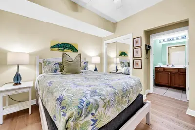 a bedroom with a large bed and a bathroom at Seychelles 602 by Emerald Coast Retreats in Panama City Beach