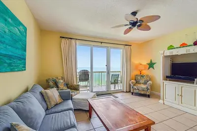 a living room with a couch and a tv at Seychelles 602 by Emerald Coast Retreats in Panama City Beach