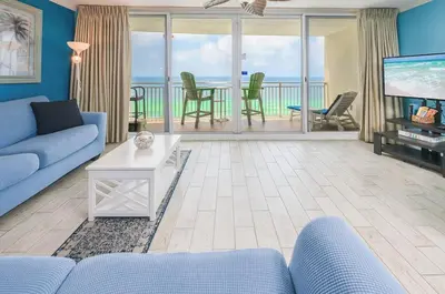 a living room with a blue couch and a tv at Emerald Beach 1628 by Emerald Coast Retreats in Panama City Beach