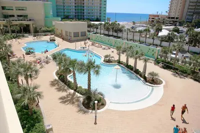 an overhead view of a swimming pool with palm trees at Emerald Beach 1628 by Emerald Coast Retreats in Panama City Beach