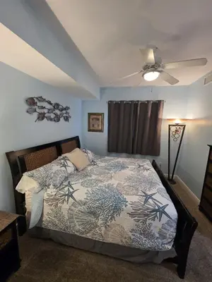 a bedroom with a bed and a ceiling fan at Beautiful gulf front condo with grill on balcony in Panama City Beach