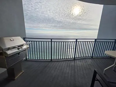 a room with a balcony with a view of the ocean at Beautiful gulf front condo with grill on balcony in Panama City Beach