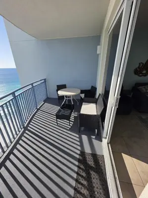 a balcony with a table and chairs and the ocean at Beautiful gulf front condo with grill on balcony in Panama City Beach